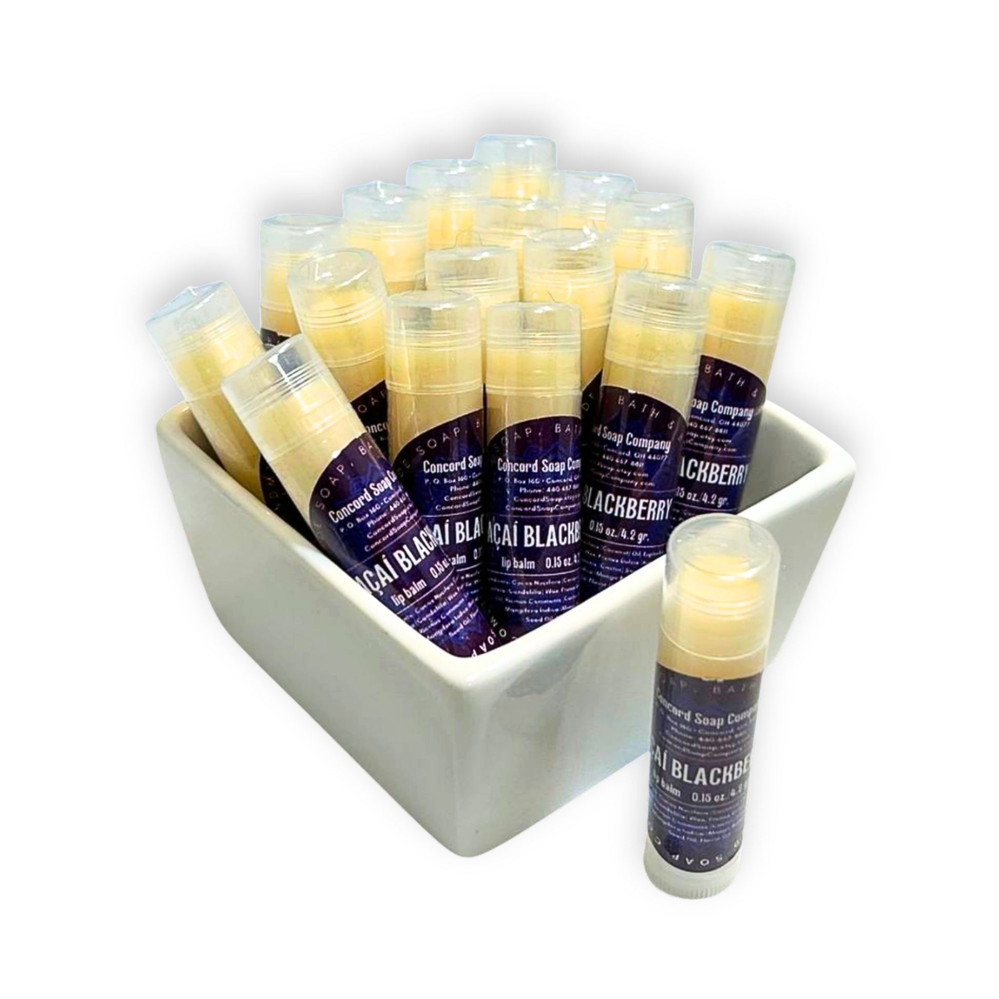 Açaí Blackberry handmade lip balm tubes in a white ceramic bowl, with one tube standing out front. This Açaí Blackberry natural lip balm by Concord Soap Company is labeled with a deep purple label that contains product and company details, and is then individually shrink wrapped for safety. Listing is for ONE lip balm.