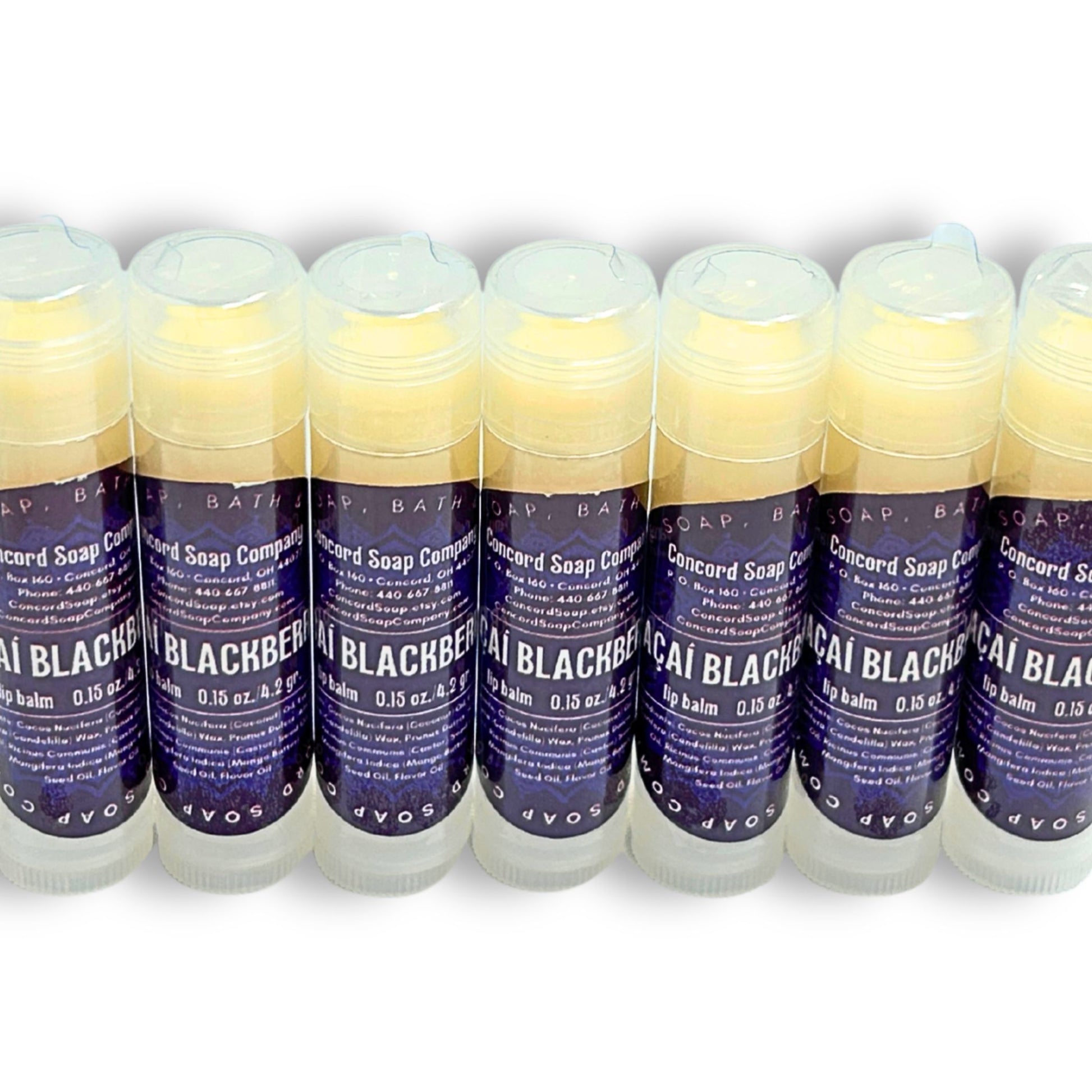 Neatly arranged row of several Açaí Blackberry lip balms, natural handmade skincare by Concord Soap Company. Each lip balm is shrink wrapped for safety and has a deep purple circle label with details. Listing is for ONE lip balm.