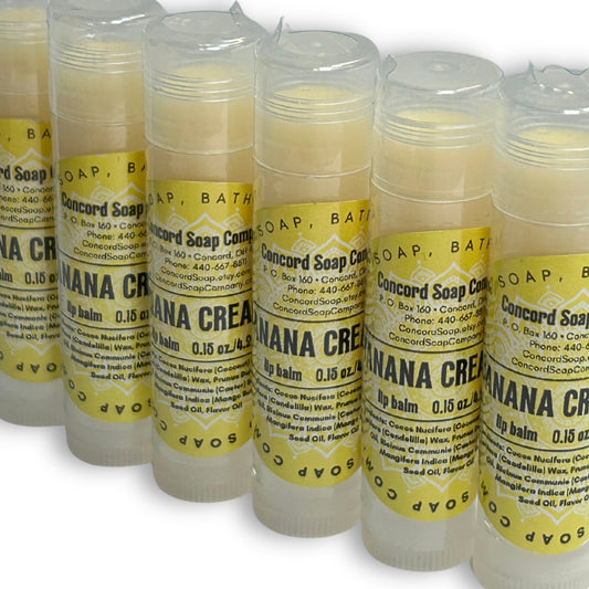 Handmade Banana Cream Pie lip balm tubes angled in a slight diagonal line. Each of these natural lip balms by Concord Soap Company has a yellow circle label with product and company details and is shrink wrapped for safety.