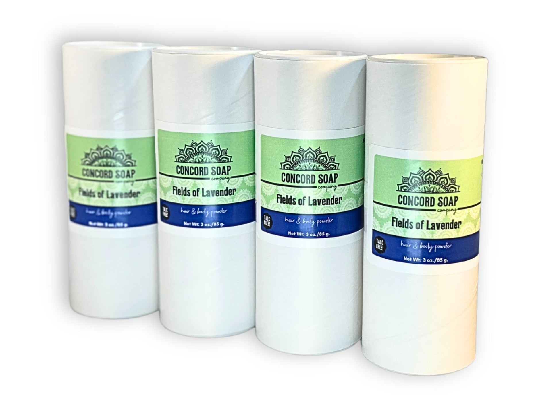 Four eco-friendly white cardboard shakers of handmade Fields of Lavender hair and body powder by Concord Soap Company, displayed on a solid white background. Each container has a green and white label featuring the company logo and product name. The tubes are arranged side by side in a row, showcasing the product packaging and branding. Natural talc-free powder in the lavender fragrance for a classic, naturally scented skincare and personal hygiene product.