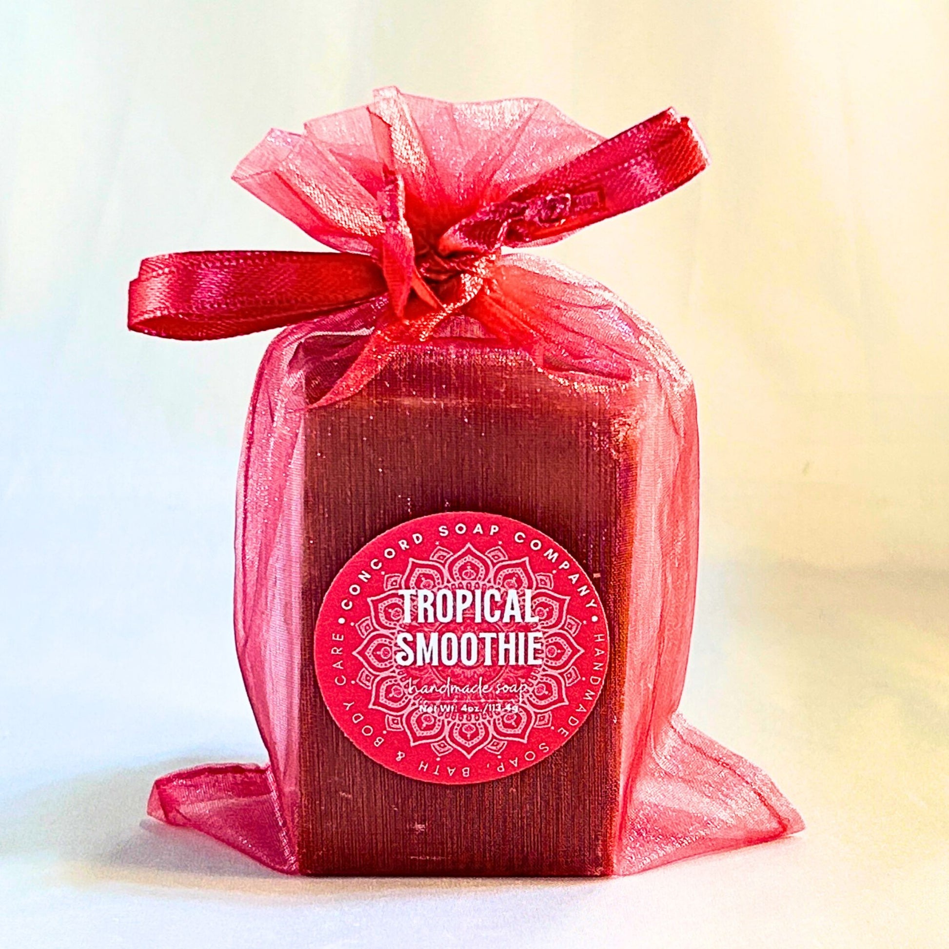 Single Tropical Smoothie handmade soap in a bright pink organza bag, angled front view with Concord Soap label visible.