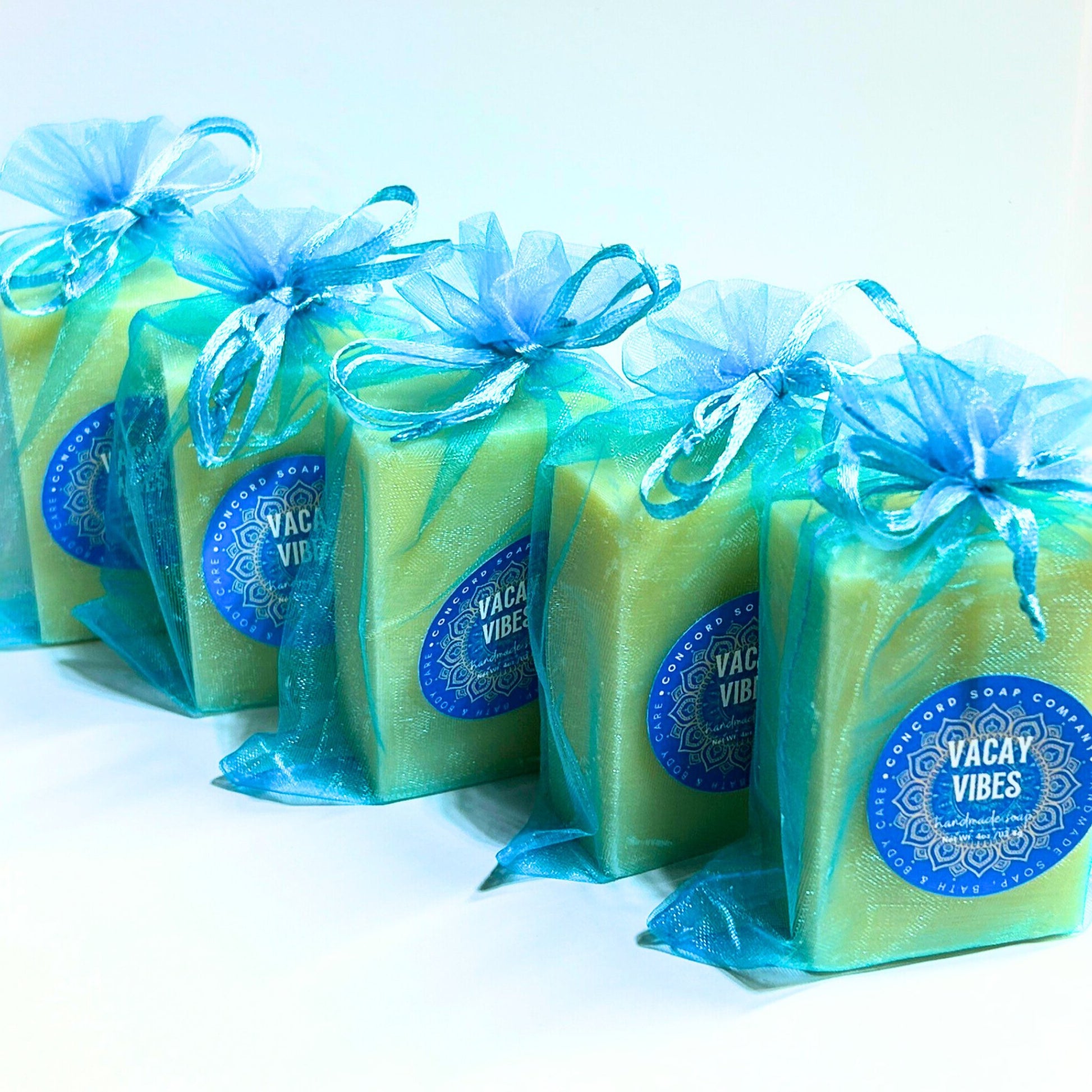 Close angled view of Vacay Vibes handmade soaps in aqua organza gift bags, vegan natural beach scent soap bars for summer vibes