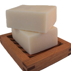 stack of two handmade soap bars on wooden soap dish