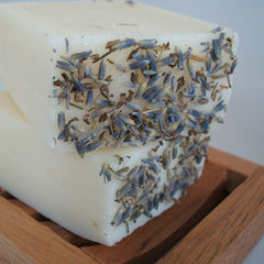 stack of two handmade lavender soap bars on wooden soap dish