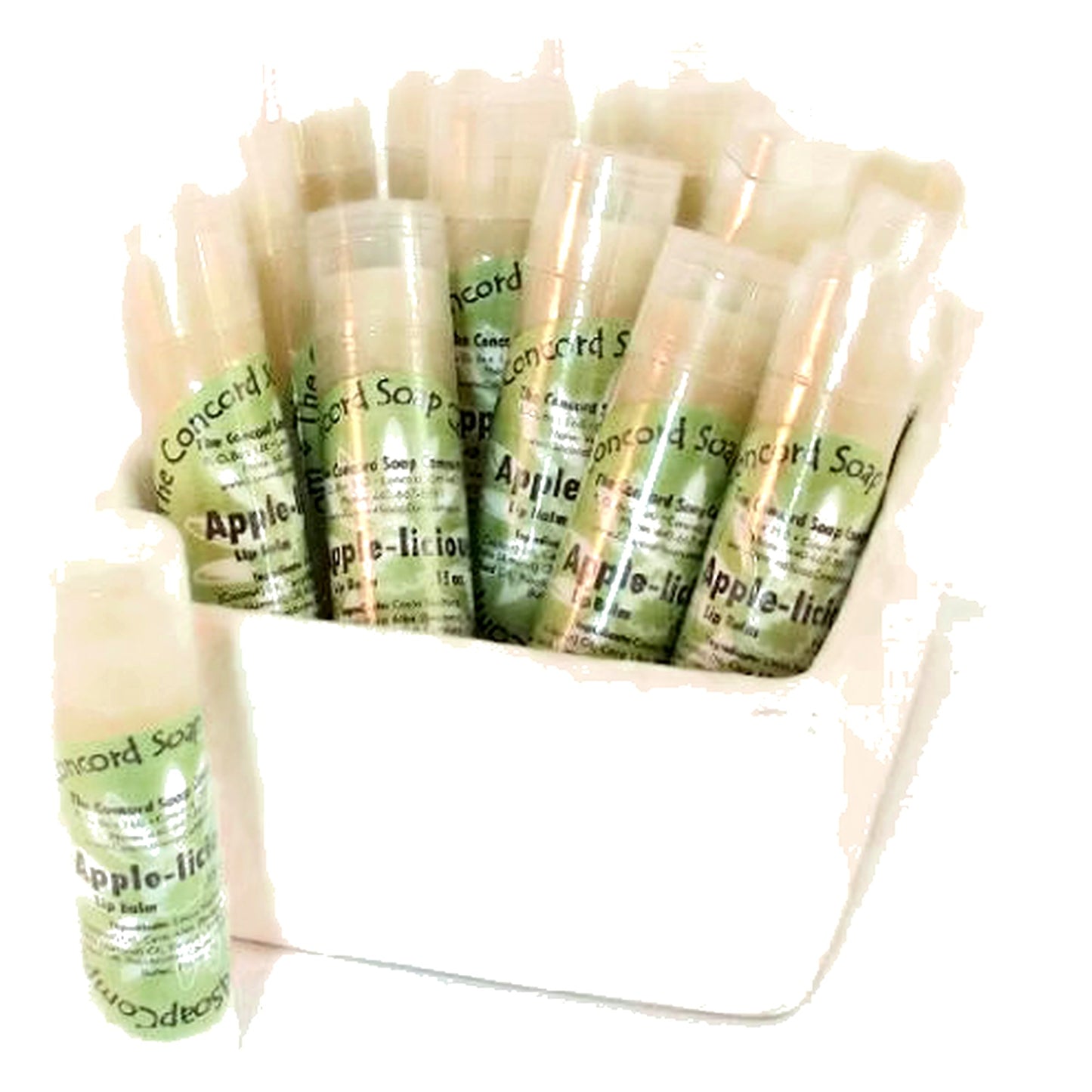 Apple-licious handmade lip balms with light green labels placed upright in a white dish, close-up angle on clean white background.