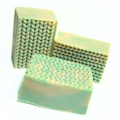 Unwrapped Cashmere Bliss soap bars arranged in a small group to show sides and texture.