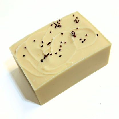 Top view of an unwrapped Cranberry soap bar with cranberry seeds sprinkled on top.