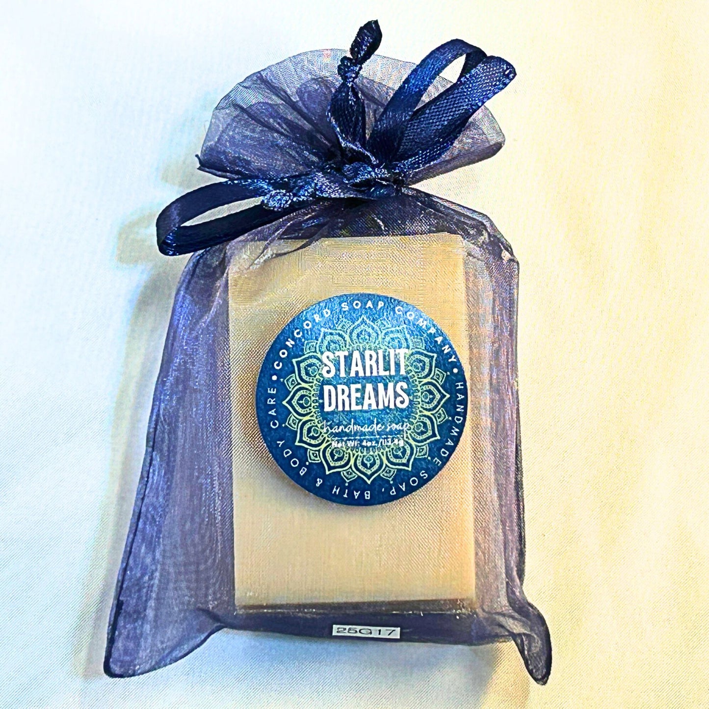 Single Starlit Dreams handmade vegan soap bar in a navy organza bag on a white background, showing the product label featuring a mandala.
