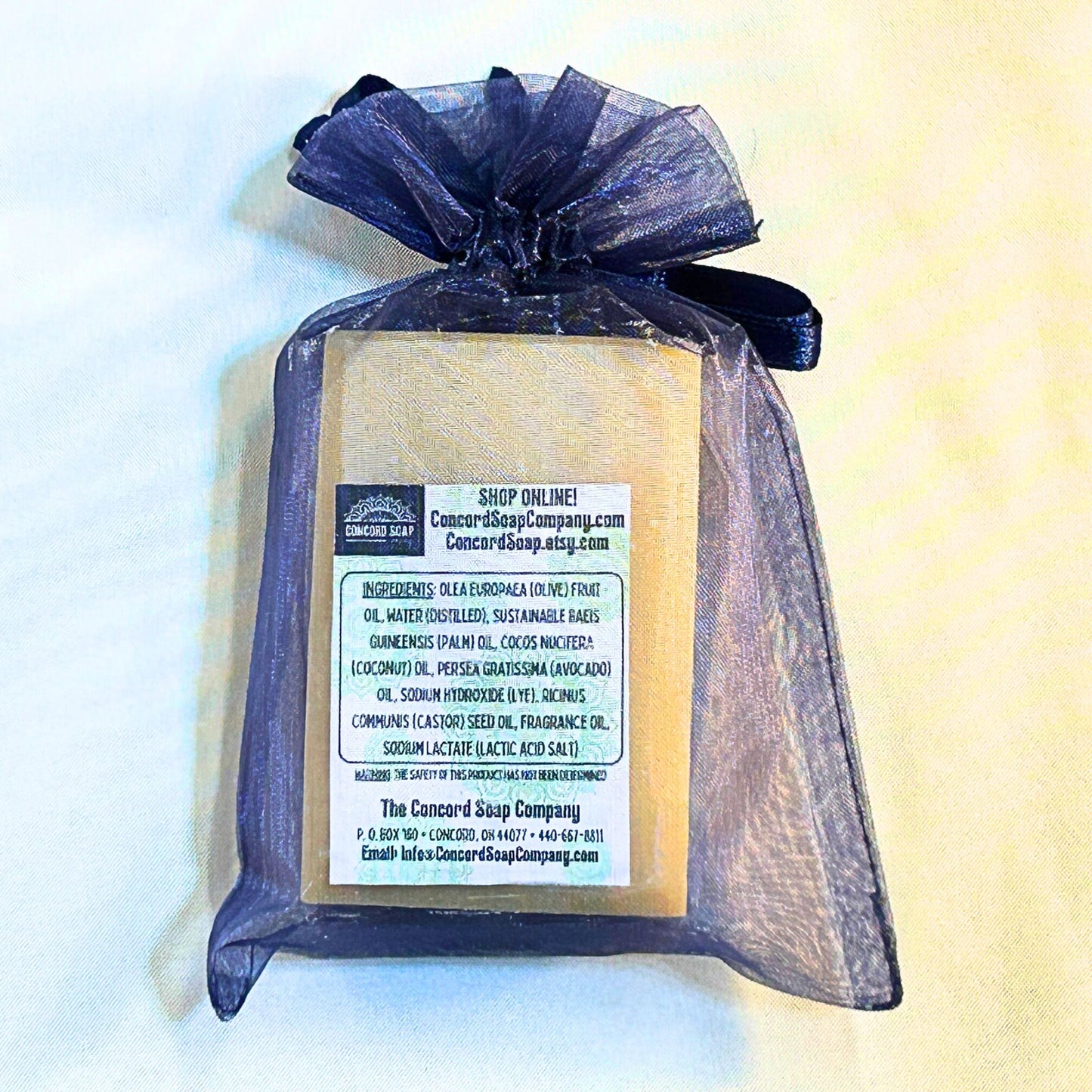 Back view of Starlit Dreams handmade vegan soap bar in a navy organza bag, showing the ingredients label and packaging.