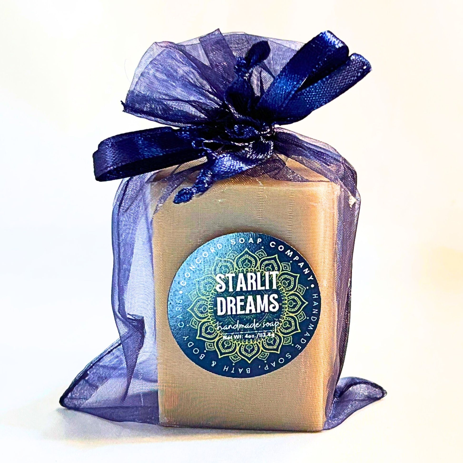 Single Starlit Dreams vegan handmade soap bar in a navy organza gift bag with satin ribbon and product label featuring a mandala.