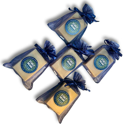 Flat-lay, top-down view of five Starlit Dreams vegan cold process soap bars in navy organza bags.