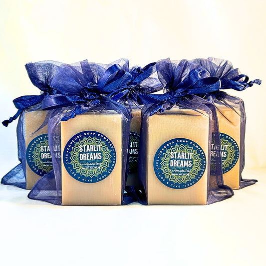 Cluster of five Starlit Dreams perfume-inspired vegan soap bars packaged in navy organza bags.