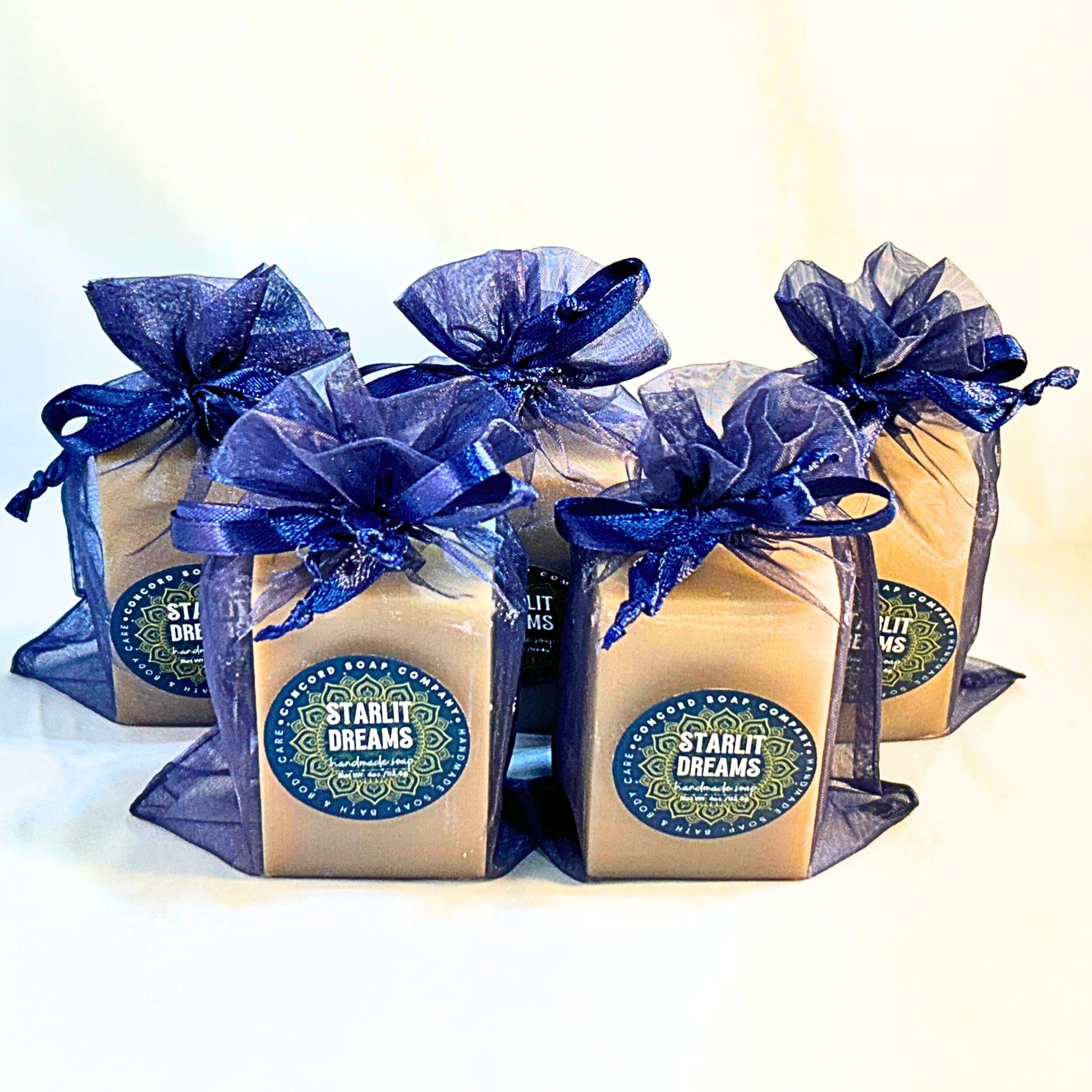 Five Starlit Dreams fruity floral perfume-scented soap bars arranged in a cluster in navy organza bags.
