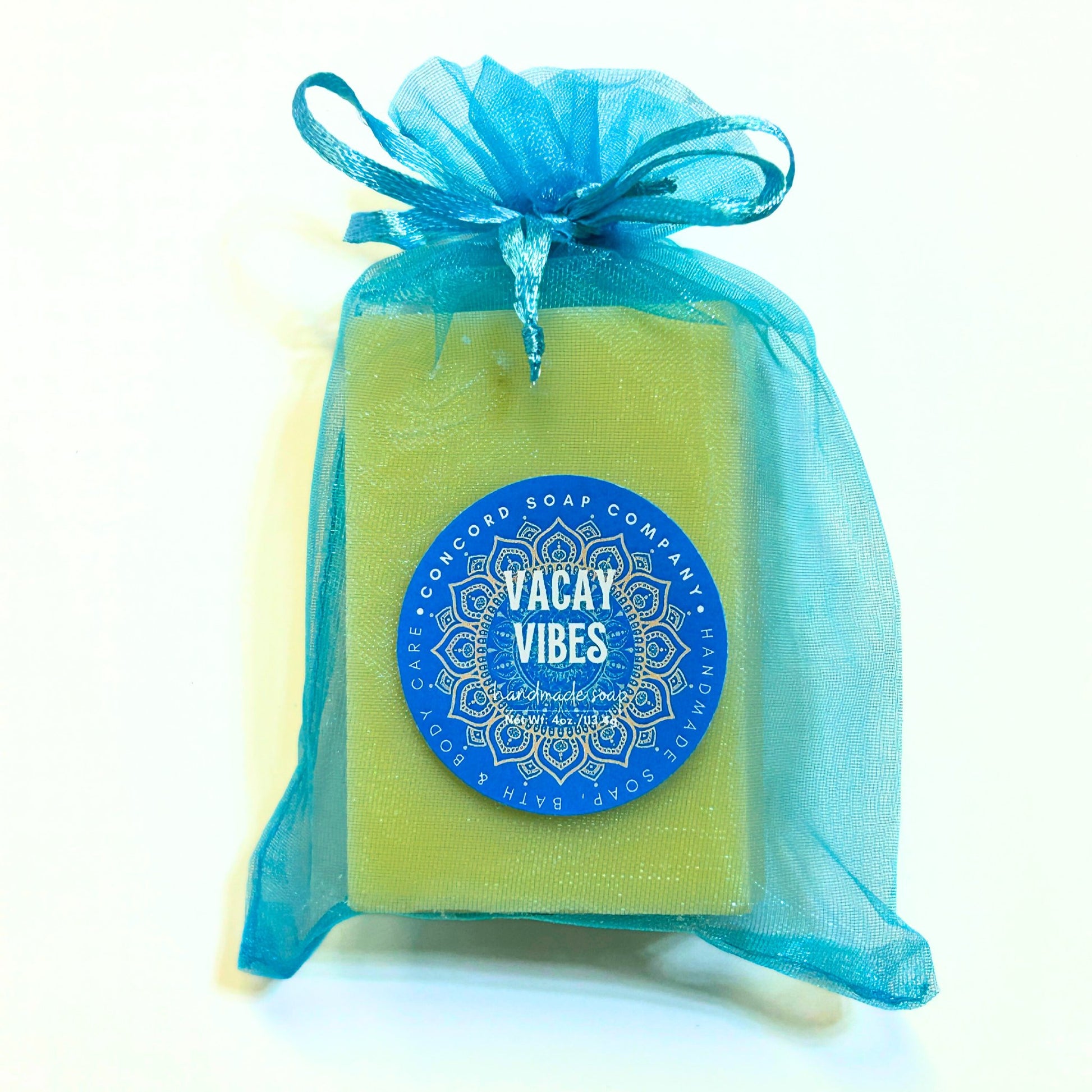 Close-up of single Vacay Vibes handmade soap bar from Concord Soap Company, packaged in aqua organza bag with blue mandala-style label.