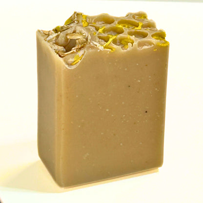 Unpackaged, single Oat, Goat & Honey soap bar standing upright, featuring the honeycomb-style top with oats and gold mica.