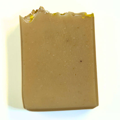 Front view of the unwrapped soap bar highlighting the smooth tan surface and textured honeycomb top edge.