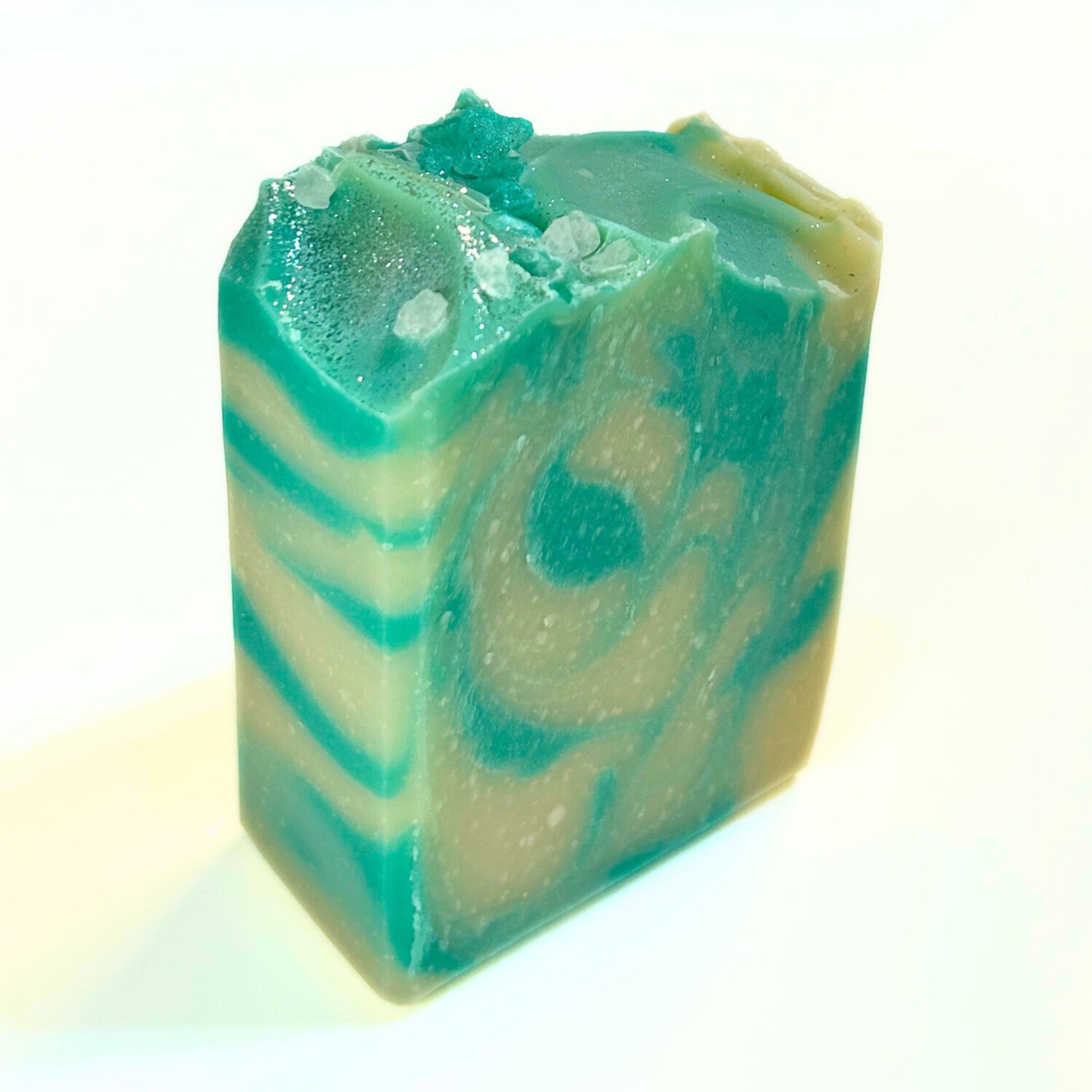 Unwrapped Comfort & Joy soap bar standing upright, showing teal and cream layered swirls.