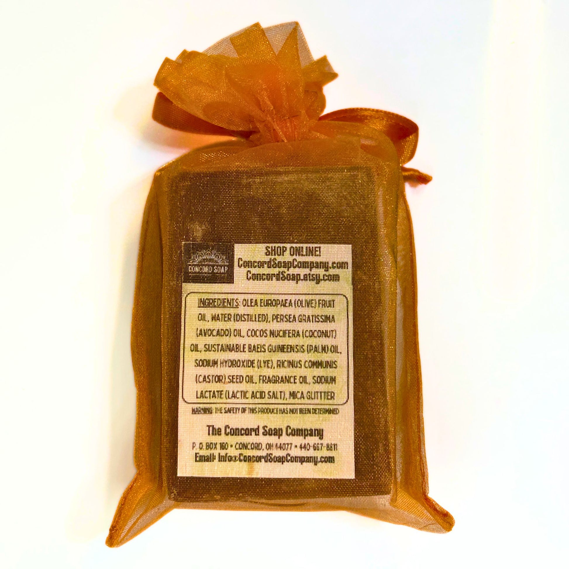 Back view of Autumn Spice soap wrapped in an orange organza bag showing ingredient label.