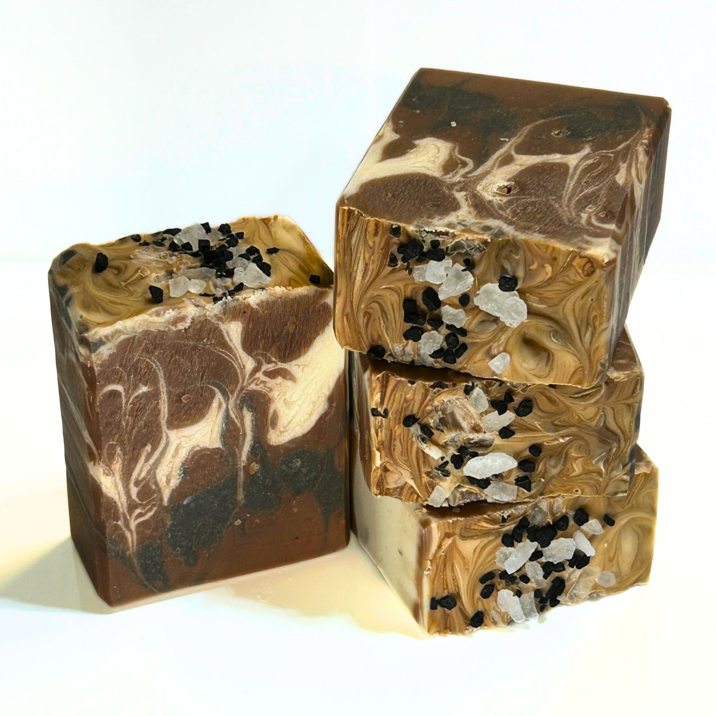 Stack of Grandpa’s Pipe soap bars side-by-side with one standing bar, showing the intricate brown and cream swirl pattern with salt crystals on top.