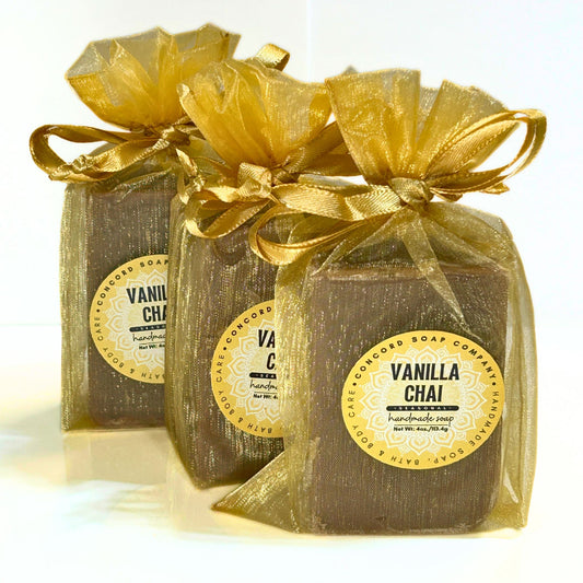 View of three Vanilla Chai soap bars in gold organza bags arranged in a diagonal line.