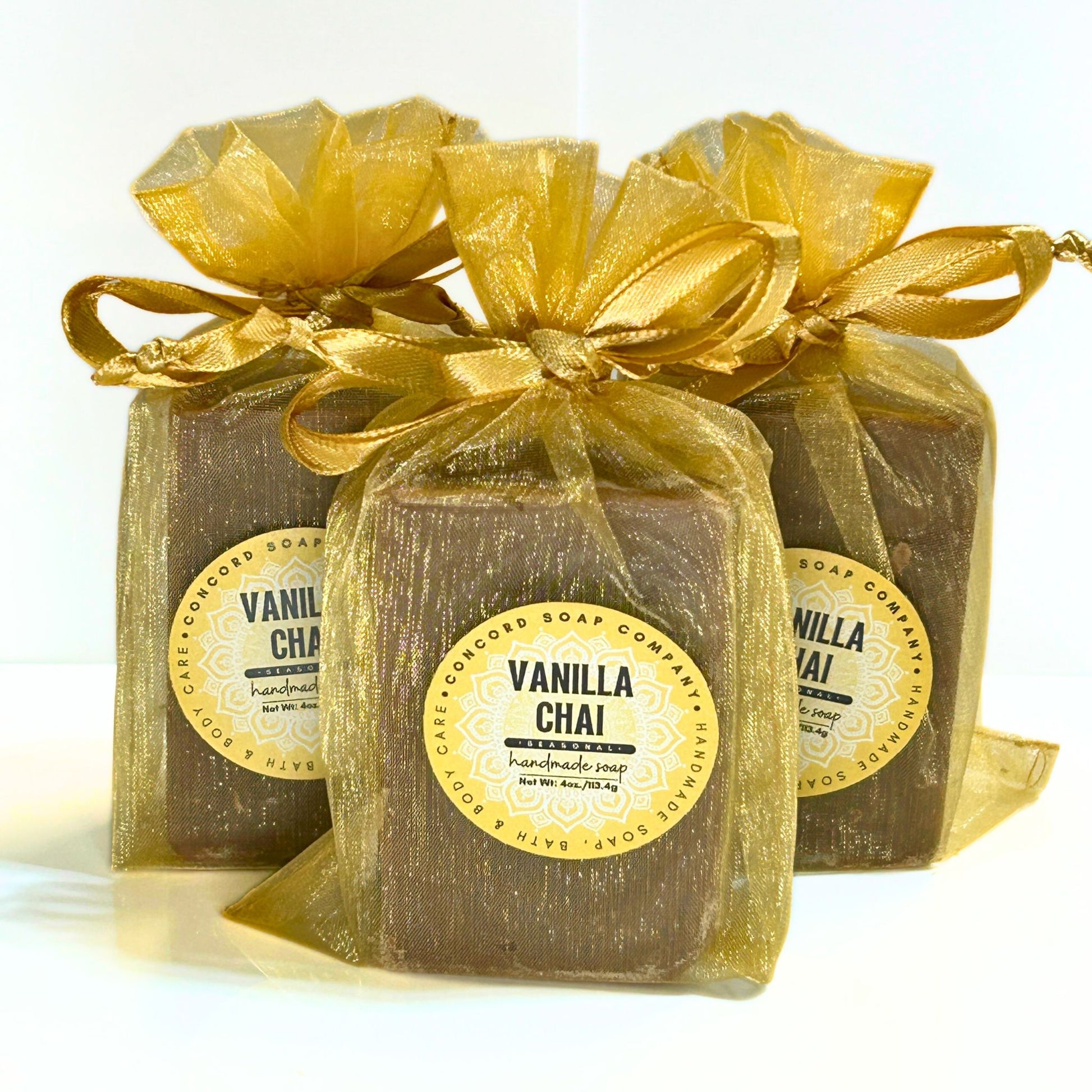 A group of three Vanilla Chai soap bars packaged in gold organza bags.